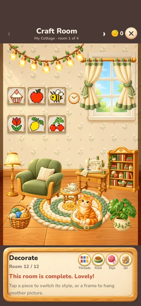 The craft room of the cottage with framed stitched pictures, an armchair and a cat in its bed